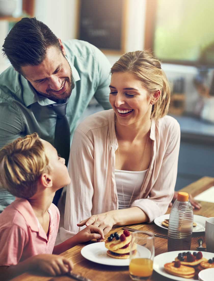 young family enjoying breakfast in new home